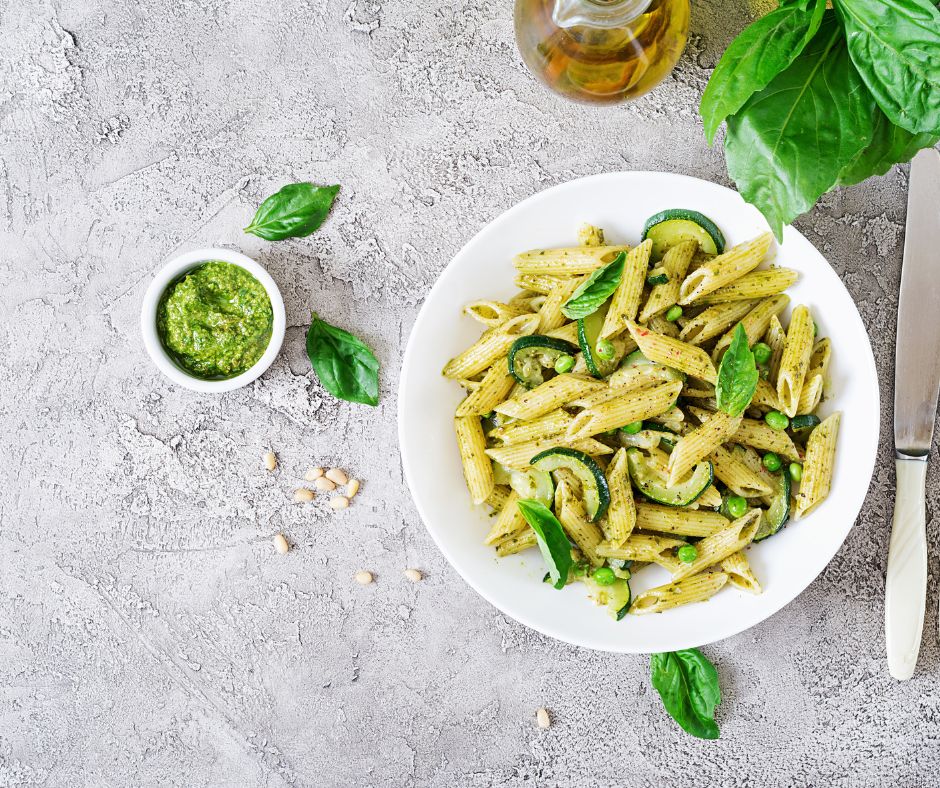 Penne Pasta with Pesto Sauce, Zucchini, Green Peas and Basil close up